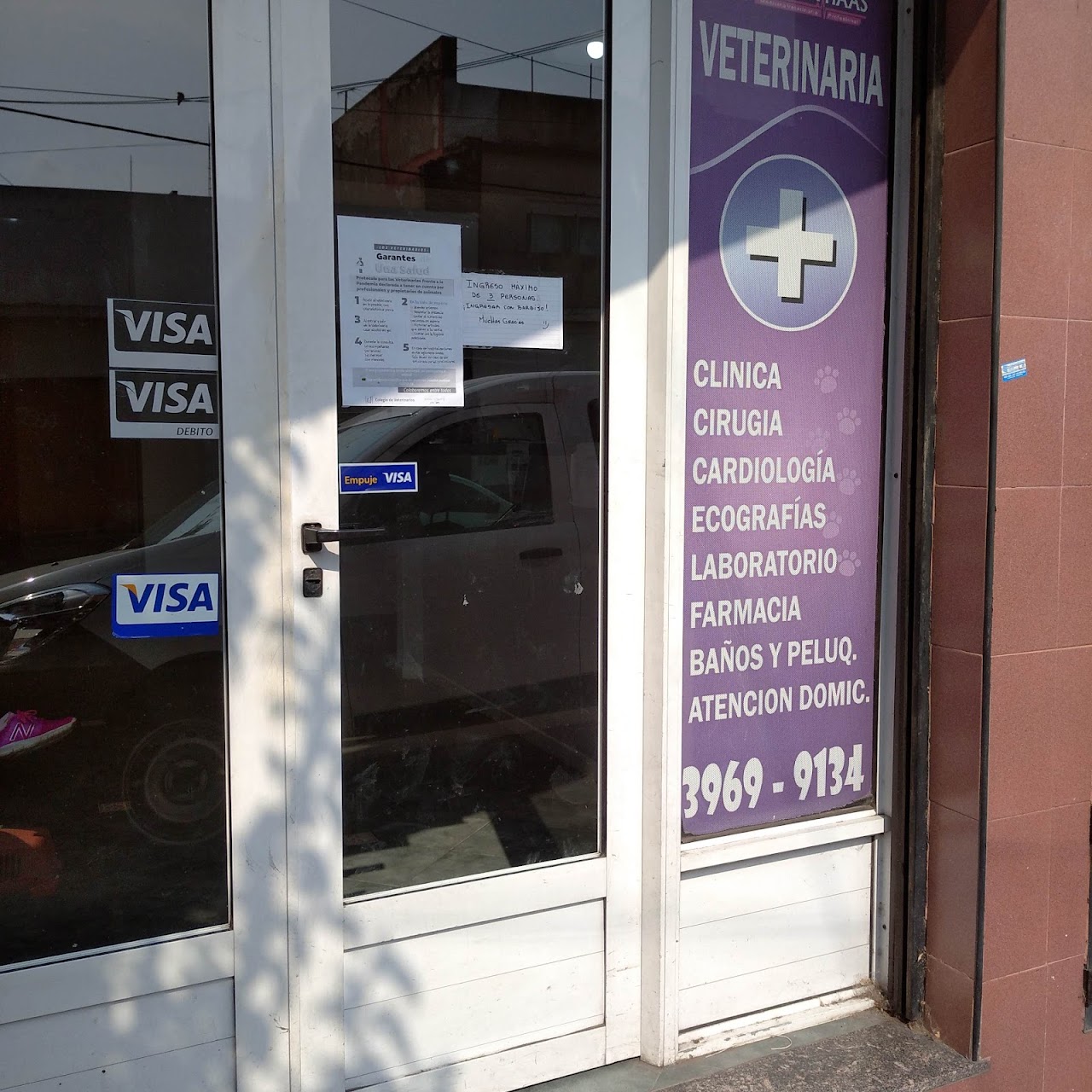Puerta de ingreso del Centro Veterinario Fabiana Haas con cartelería de servicios